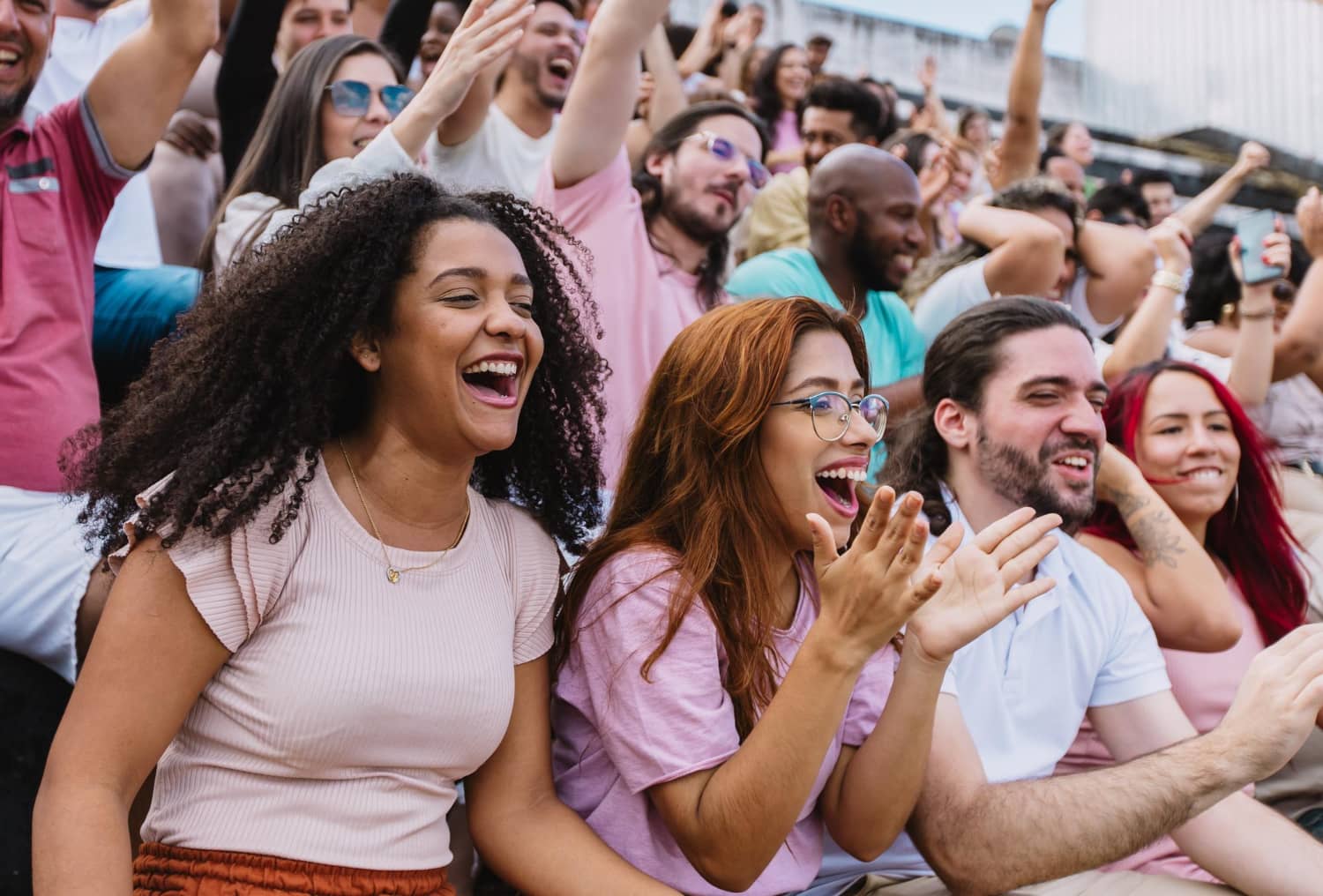 group of people cheering together showing community support and connection